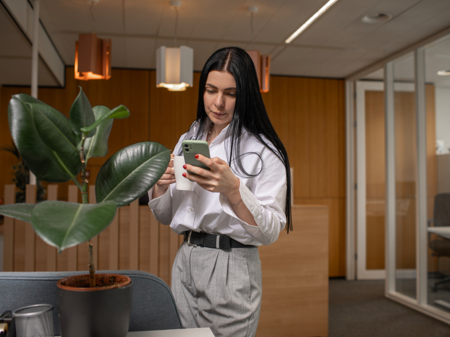 Woman in white blouse looking at her smartphone