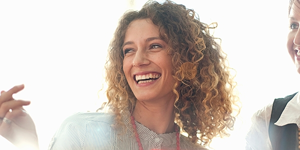 A woman reading a red book smiling.