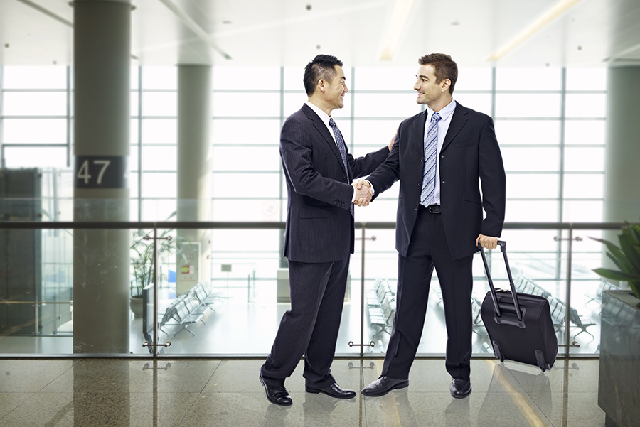 Two men shaking hands in airport