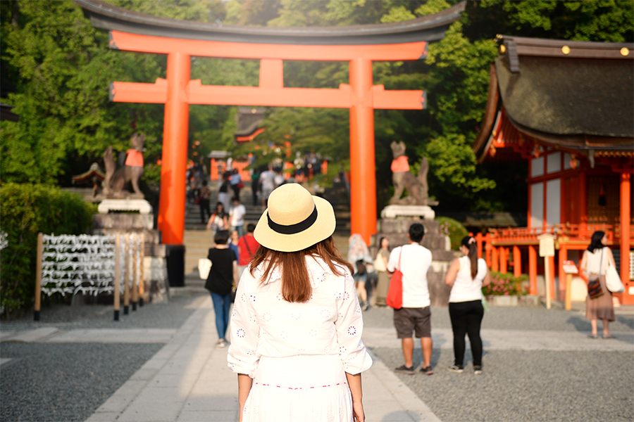 Woman walking with white hat on head